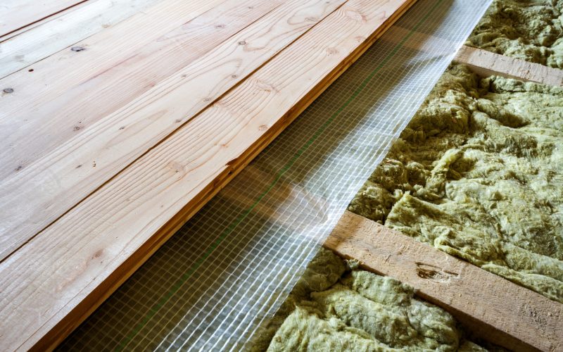 Installation of new floor of wooden natural planks and mineral wool insulation for isolation and keeping warmth. Modern technologies, warm comfortable house and eco-friendly insulation concept.